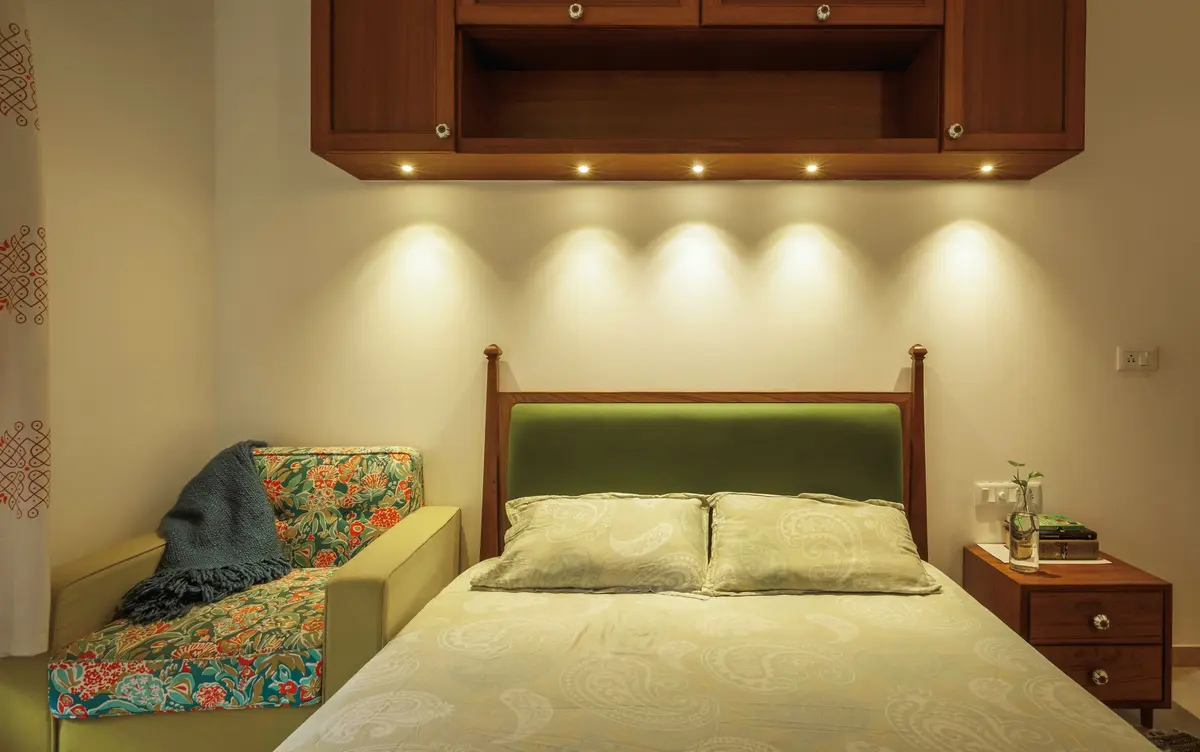A Half poster bed with deep green upholstery headboard
